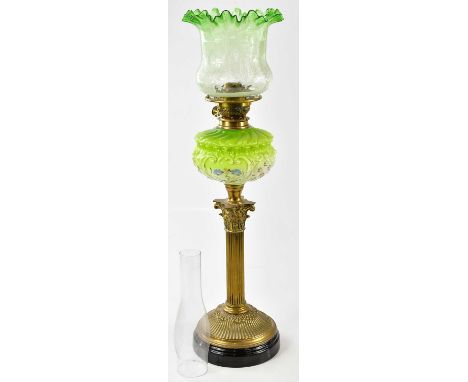 A Victorian oil lamp, the green and clear glass shade with wavy rim above etched floral decoration, above the green and clear