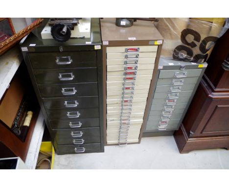 Horology: three steel chest of drawers containing clock tools and parts;&nbsp;together with a small quantity of veneers. 