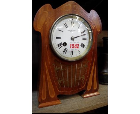 An Art Nouveau mahogany and inlaid mantel clock,&nbsp;with enamel dial, 26cm high, with pendulum.&nbsp; 