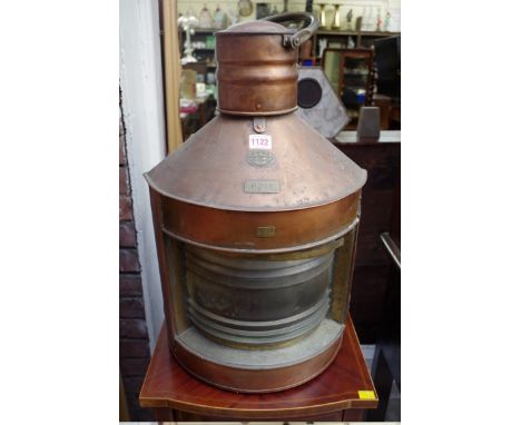 An old large copper ships 'port' lantern, labelled 'Supplied by The Great Grimsby Coal, Salt &amp; Tanning Co Ltd', and numbe