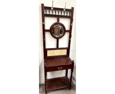 A Victorian mahogany hall stand with a central circular mirror, drawer and shelf