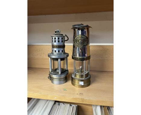 An aluminium miners lamp with a brass plaque for H.W. Thomas together with a Thomas and Williams miners lamp