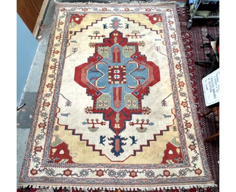 A room size rug with a cream ground and medallions, to light blue guard stripes, 310 x 425cm