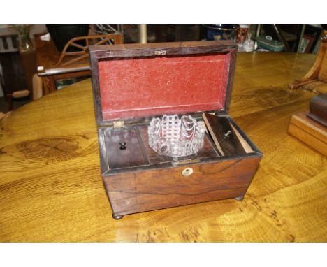 Regency rosewood sarcophagus shaped tea caddy on bun supports containing a cut glass mixing bowl 