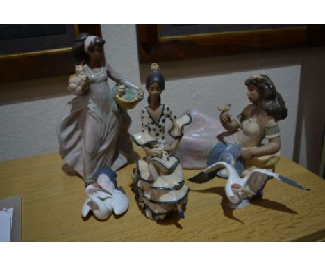 Three Lladro figures and a pair of Lladro model herons
