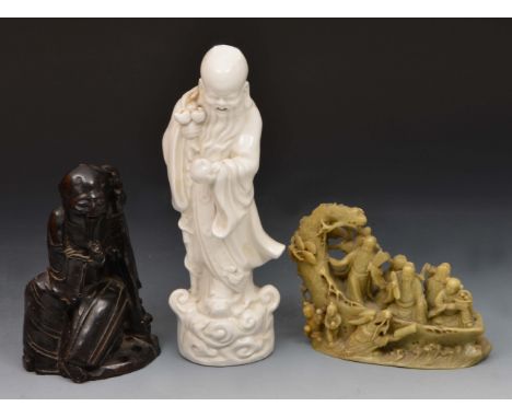 Chinese carved soapstone figure Shou Lao, one other Chinese soapstone group and a blanc de chine model of Shou Lao (3)