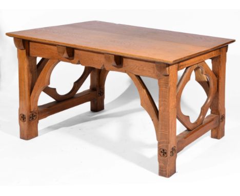 Gothic Revival light oak table the rectangular top on chamfered supports carved with Gothic motifs, 77cm high, 123cm wide