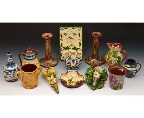 Group of Devon Pottery including a pair of Torquay candlesticks, a plaque with inscription, two wall pockets and other pieces