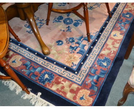 Chinese small carpet with pale pink ground central panel and traditional Chinese motifs within a blue and red border, 198cm x