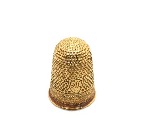 A gold thimble with monogrammed initials to the shield DL. Unhallmarked, assessed as 21ct gold. Weight 8.74 grams. 
