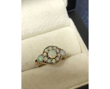 A vintage opal cluster ring. The ring stamped 375, assessed as 9ct gold. Ring size N. Weight 3.16 grams. 