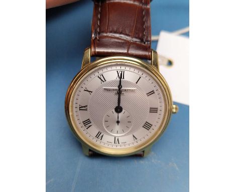 Frederique Constant, Geneve. A gold-tone slimline wristwatch with machined silvered dial and subsidiary seconds. on a leather