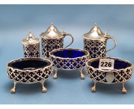 Three blue glass lined George III silver salts by Hennell's, London date mark obscured matched together with a pepper and two