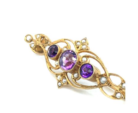 A vintage 9ct gold, amethyst and seed pearl bar brooch. Stamped 9ct to the reverse. Width 4.3 cm. Weight 3.72 grams. 