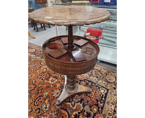 A 19th cwentury walnut teapoy, the top rising to reveal four cannisters and receivers for two glass bowls, the column leaf ca