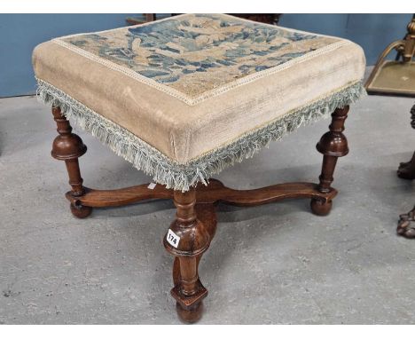 A mahogany stool with the 18th century foliage tapestry seat above turned legs joined by an X-shaped stretcher above the bun 
