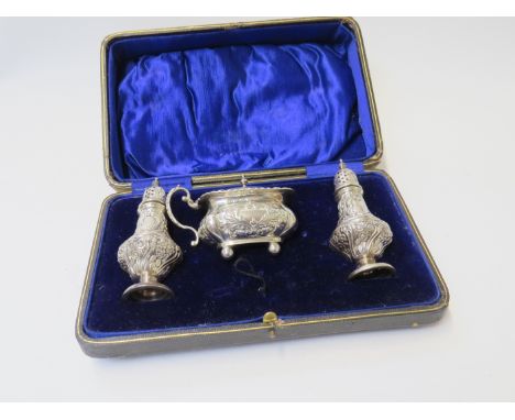 An Edwardian William Hutton &amp; Sons Ltd silver three piece cruet set, Birmingham 1907/1908, cased. One pepperette with lar