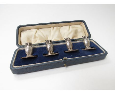 A set of four George VI Sampson Mordan &amp; Co, silver menu holders in the form of owls with ruby coloured inset eyes, Londo