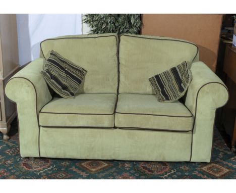 A pale green cord two seater sofa, matching lot 98