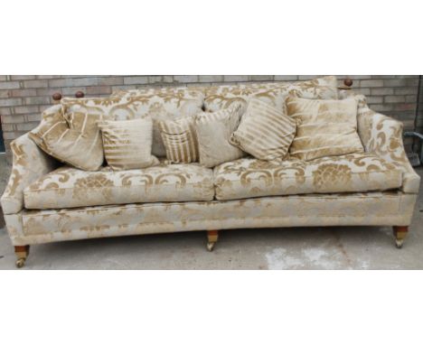 A modern Duresta Knowle type sofa, upholstered in beige damask material, on short tapering legs, with brass castors, and a co