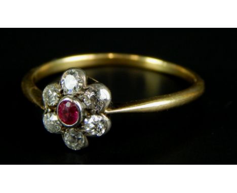 A dress ring, set with diamonds and a ruby, in a floral cluster, yellow metal, unmarked, 1.9g all in. 