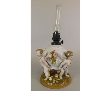 A German porcelain table lamp, modelled on a flower encrusted wicker basket supported by three cherubs, on a circular moulded