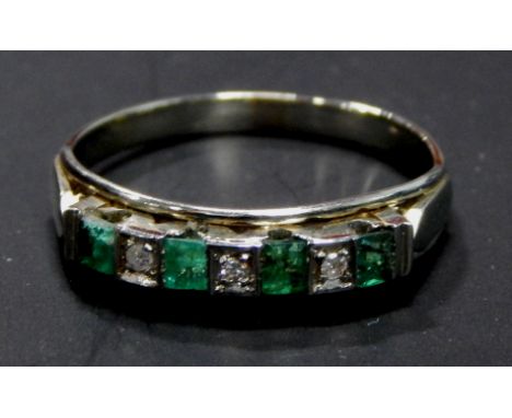 An emerald and diamond dress ring, set with four square cut emeralds, and four illusion set tiny diamonds, white metal band, 