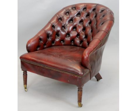 A vintage style leather upholstered tub shaped chair, with a button back and seat on turned tapering leg, with brass castors.