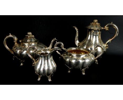 A Victorian silver four piece tea service, of lobed form, engraved with flowers and foliate scrolls, the hinged lids each wit