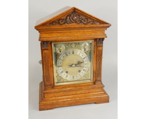 A late 19th/early 20thC mantel clock, the rectangular dial with subsidiary slow/fast, chime silent, in an oak portico shaped 