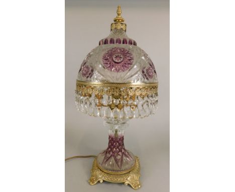 An amethyst flashed cut glass table lamp, with a domed shade hung with prismatic drops, on cast metal base, 27cm high.