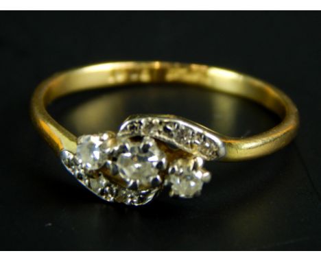 An 18ct gold dress ring, with three central diamonds, of twist design with smaller diamonds illusion set, 1.9g all in. 