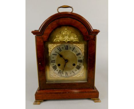 A Continental mahogany bracket clock, with a loop handle, the arch dial stamped German, on ogee bracket feet, 37cm high.