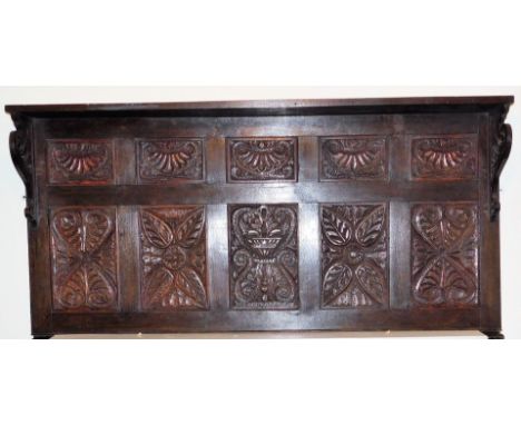 A carved oak overmantel, with shelf and stylised floral panels, 160cm W.