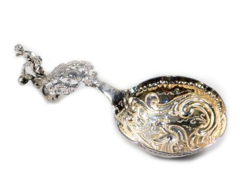 A late 19thC Dutch caddy spoon, with highly elaborate pierced handle, child knop and partially gilded bowl, heavily repousée 