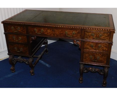 An early 20thC mahogany and walnut kneehole desk, with green leather skiver, gadrooned border, three frieze drawers and two f