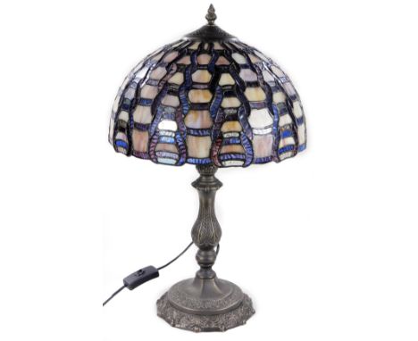 A 20thC Tiffany style table lamp, with glass shade predominately in purple and lilac, on a metal stem and shaped base, 57cm H