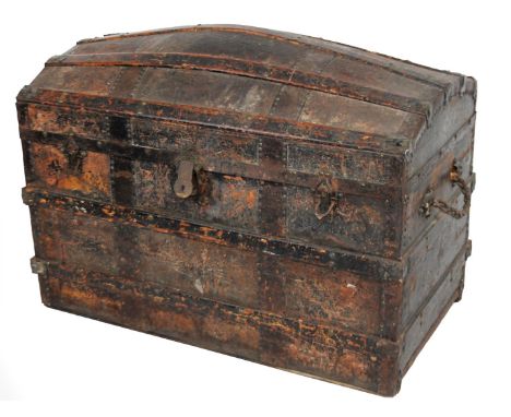 A late 19thC domed top trunk, partially studded and wooden bound with a plain interior with elaborate escutcheon and rope han