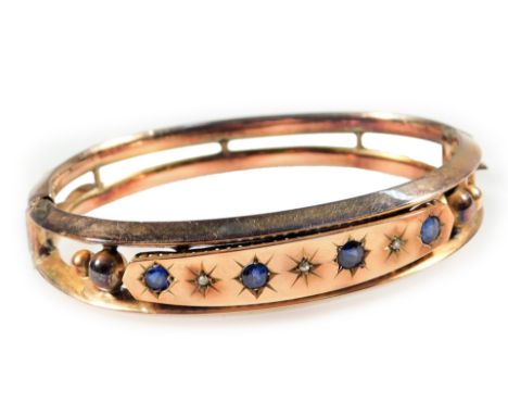 A Victorian hinged bangle, set with illusion set sapphire and diamonds, four sapphires and three diamonds, with two row pierc