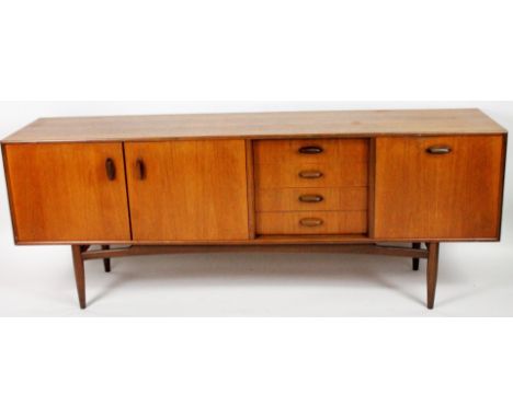 A 1970s G-Plan type vintage teak sideboard, of rectangular form with four cutlery drawers, fall front and two further cupboar