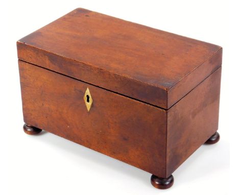 An early 19thC mahogany tea caddy, of rectangular form with lozenge escutcheon and a sectional interior, on compressed bun fe