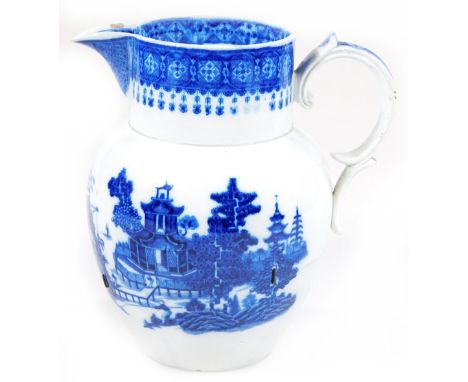 An 18thC Pearlware pottery large blue and white jug, printed with a Spode type Willow pattern design below a shell and diaper