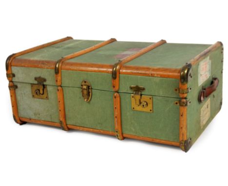 An early 20thC travel trunk, partially wooden and metal bound with pressed green material and luggage labels, 33cm H, 79cm W,