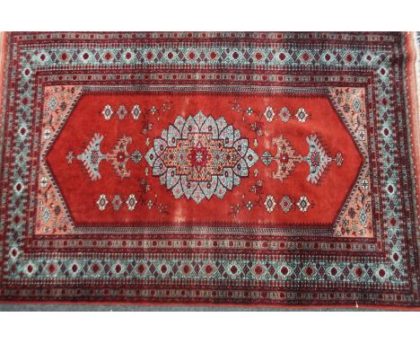 A Middle Eastern rug, in a repeat floral pattern predominately in red and light blue with yellow highlights, 127cm W.