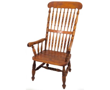 A 19thC stained ash and elm chair, with overhanging comb top, double spindle back and shaped arms, on double ring forelegs, j