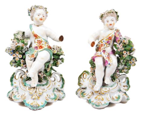 A pair of Derby porcelain cherubs, on rococo bases, patch mark, 18cm H.  (2, AF)