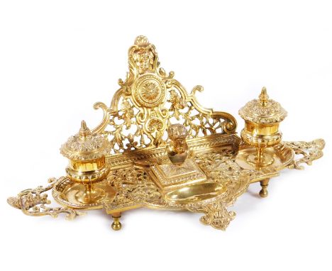 A 19thC rococo design brass inkwell, heavily pierced with scroll and satyr mask heads, the back section with space for pen, f