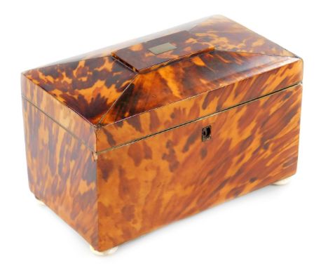 A Regency tortoiseshell tea caddy, of rectangular sarcophagus form with white metal cartouche, with a fitted part foil interi