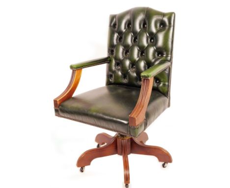 A swivel office chair, in button back green leather finish material, on five reeded legs, terminating in castors, 92cm H. 