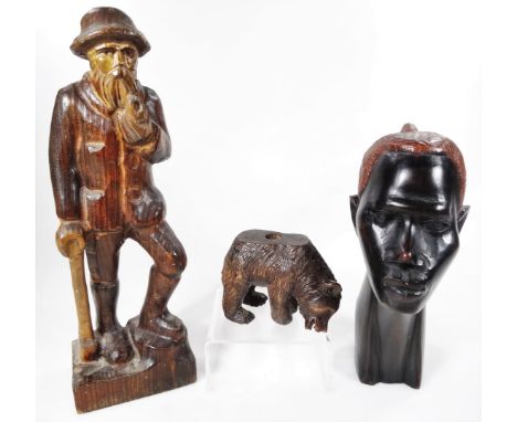 A 20thC carved Black Forest bear, 8cm H, an African tribal head and a treen figure of a gentleman smoking pipe. (3)